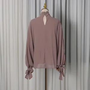 Back view of high neck long sleeve blouse with rhinestone trim and tie cuffs