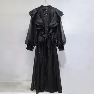 Close-up of black vintage palace style dress with ruffle collar and tie waist detail
