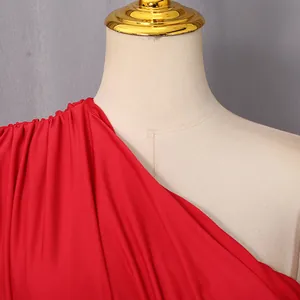 Dettaglio elegante vestito rosso monospalla con design a pieghe raffinate e tessuto morbido