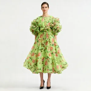 Detailed view of a vintage green rose print dress with layered ruffle puff sleeves and bow