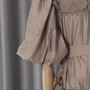 Detailed view of champagne puff sleeves and hollow flower embroidery on a French dress