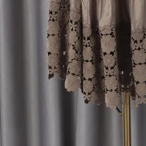 Macro detail of the floral hollow lace hem on a French style solid color short dress.