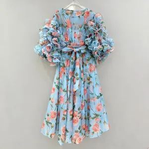 Detailed view of a vintage light blue dress with rose print and ruffled puff sleeves.