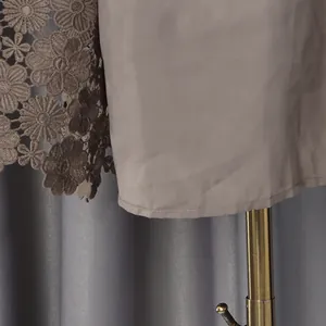 Detailed macro shot of floral lace embroidery and smooth lining on a brown dress.