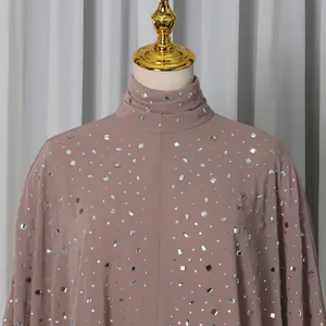 Close-up of elegant dusty rose high-neck top with sparkling rhinestone embellishments.