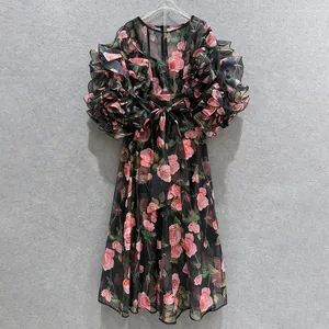 Detail view of a vintage rose print dress with ruffle puff sleeves and waist bow.