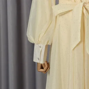 Detail view of vintage cream dress with glitter dots, puff sleeves and bow tie waist