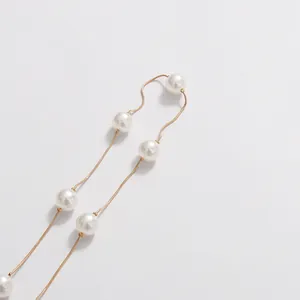Macro view of exquisite white pearl decorative chain on elegant holiday dress