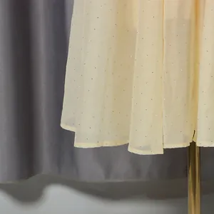 Detail view of cream vintage dress fabric showing delicate glitter dots and sheer texture
