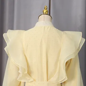 Close-up detail showing the romantic back ruffles and sparkling sequins on a yellow palace dress