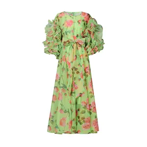 Macro detail of romantic lime green floral dress with voluminous ruffle puff sleeves and bow.