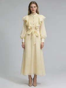 Elegant retro cream maxi dress featuring ruffled details and a tie waist belt.