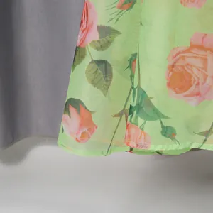 Detailed close-up view of romantic pink rose print on a light green chiffon palace style dress.