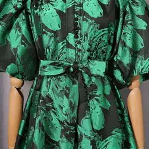 Close-up of vintage green floral dress with puff sleeves and bow waist detail.