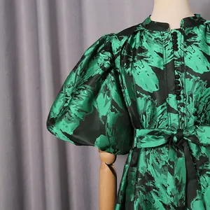 Detailed view of elegant green floral puff sleeve dress with chic button closure and tie waist