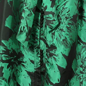 Close-up of green floral vintage dress with button detail and bow tie neck