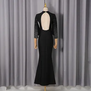 Vista posterior de este elegante vestido de noche negro sin espalda con mangas de pedrería