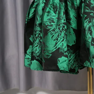 Close-up of green and black floral jacquard fabric on a French vintage dress