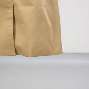 Detailansicht des Saums und der Nähte eines klassischen khakifarbenen langen Windbreakers.