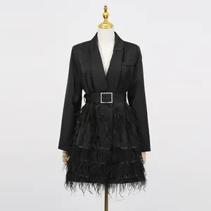 Detailansicht schwarzes Blazer-Kleid mit Federbesatz und Gürtel, elegante V-Ausschnitt.