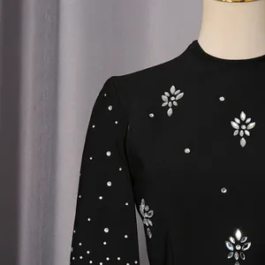 Detalle de un vestido de noche negro estilo francés con brillantes motivos florales strass.