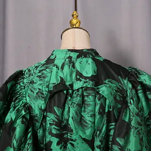 Close-up structural detail of the back and puff sleeves on a vintage green floral dress