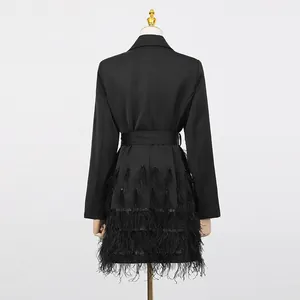 Rückansicht eines eleganten schwarzen Blazerkleides mit Gürtel und Straußenfeder-Saum.