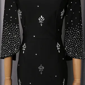 Primer plano de vestido de noche negro con intrincados motivos florales de strass y lentejuelas.