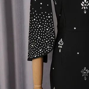 Detalle de cerca de un vestido de noche negro con intrincados patrones de flores de strass