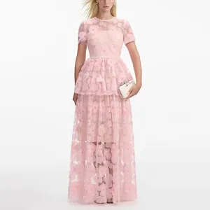 Detalle de vestido largo de malla bordada rosa con detalle de perlas en la cintura.