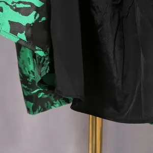 Detail view of green and black floral jacquard fabric and black lining of a vintage dress