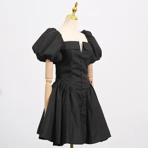 Detailed side view of a French black puff sleeve dress on a professional mannequin stand
