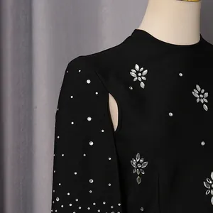Detalle de un vestido de noche negro estilo Hepburn francés con pedrería plateada
