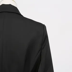 Hochwertige Nahaufnahme der Schulter- und Reversnähte eines schwarzen Blazer-Kleides