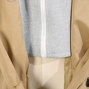 Detailaufnahme eines khakifarbenen Damen-Windbreakers mit grauem Kapuzen-Reißverschluss