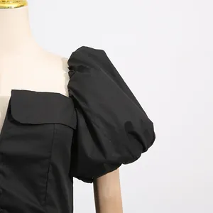 Close-up detail of a black French style dress featuring elegant puff sleeves and square neck.