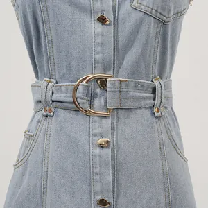 Detail des Hüftgürtels mit goldener Schnalle an einem hellblauen Jeanskleid für Damen