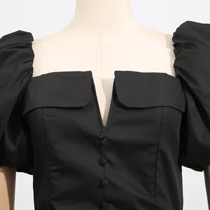 Detailed view of elegant French style black dress with V-neckline and puff sleeves