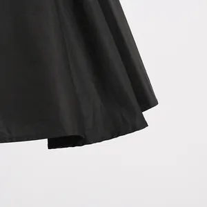 Close-up detail of the elegant pleated hem on a high-waisted black French style mini dress