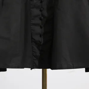 Close-up of elegant fabric-covered buttons on a French style high-waist black dress