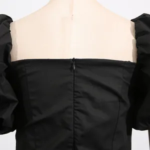 Detailed back view showing the invisible zipper and puff sleeves of black dress