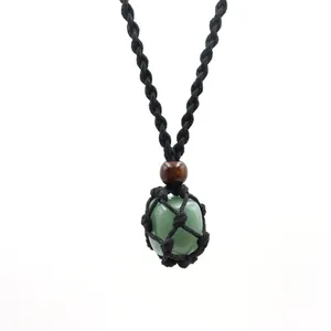 Close-up of natural green stone crystal pendant in black hand-woven macrame net bag