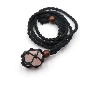 Detail view of pink rose quartz raw stone in black woven net pouch necklace
