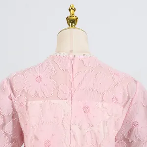 Primer plano de un vestido de malla rosa con bordado floral en 3D y elegantes detalles de perlas