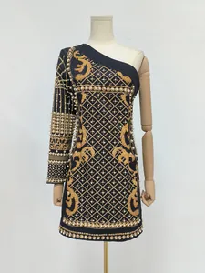 Detailed macro view of a black retro dress featuring gold prints and pearls