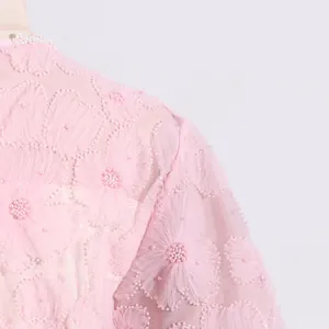 Primer plano de bordado floral rosa y perlas en un elegante vestido de tul