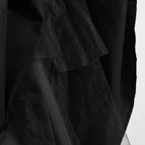 Detailed close-up of layered black mesh and solid fabric of a French style dress