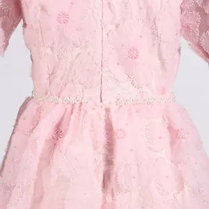 Primer plano de vestido rosa de malla bordada con delicadas perlas en la cintura
