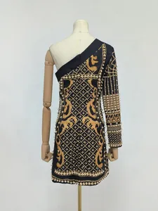 Detail of French royal style one-shoulder dress with gold embroidery and pearls
