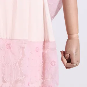 Primer plano de un vestido rosa estilo francés con bordado floral y perlas rosas